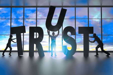 Silhouettes of people assembling large letters to form the word TRUST, symbolizing Agile Solutions’ commitment to building trustworthy, authentic brand identities for service-based businesses.